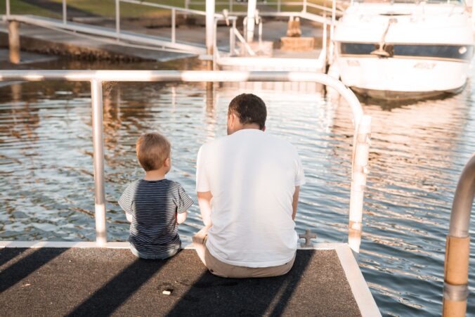 Dad with child on sitting on a dock